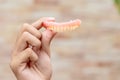 A man is holding dentures in his hands. Removable dentures flexible. False teeth