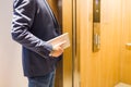 Man holding digital tablet while entering wooden elevator