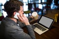 Man holding disposable coffee cup while talking on mobile phone Royalty Free Stock Photo