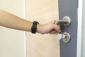 Man holding door handle of stainless steel on wooden door to open Royalty Free Stock Photo