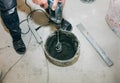 Man is holding drill mixer in his hands. Maintenance repair works renovation in the flat. Restoration indoors. Man is mixing grey Royalty Free Stock Photo