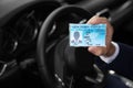 Man holding driving license in car, closeup. Royalty Free Stock Photo