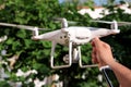 Man is holding a drone in hand and using of new technology. White quad copter Drone and photographer man hands. Royalty Free Stock Photo