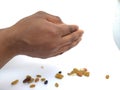 Man holding and dropping from distance of mixed dry fruits isolated on white background