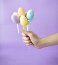 Man holding easter eggs on stick on violet background Royalty Free Stock Photo