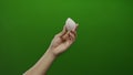 Man holding egg-shaped object against green background, hand poised elegantly, displaying precision and focus, isolated on vibrant Royalty Free Stock Photo