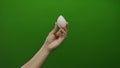 Man holding egg-shaped object against green background, hand poised elegantly, displaying precision and focus, isolated on vibrant Royalty Free Stock Photo