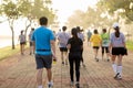 Man holding energy drink in a group of people exercise in the park in morning.