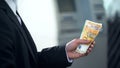 Man holding euro banknotes withdrawn from ATM, good service, business trip