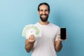 Man holding fan of euro banknotes and smart phone with black blank screen, making money online. Royalty Free Stock Photo