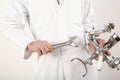 Man holding faucet and adjustable spanner in each hand. Conceptual image
