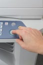 Man holding finger on a start button of laser printer Royalty Free Stock Photo