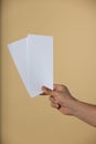 Man holding flyers on beige background, closeup. Mockup for design Royalty Free Stock Photo