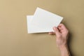 Man holding flyers on light brown background, closeup. Mockup for design Royalty Free Stock Photo