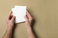 Man holding flyers on light brown background, top view. Mockup for design Royalty Free Stock Photo