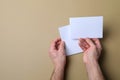 Man holding flyers on light brown background, top view. Mockup for design Royalty Free Stock Photo
