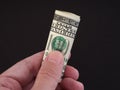 A man holding a folded one hundred dollar bill in his hand Royalty Free Stock Photo