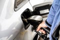 Man holding fuel nozzle, filling gas tank of diesel car covered with some rain drops Royalty Free Stock Photo