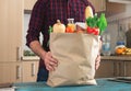 Man holding full paper bag of healthy food