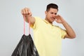 Man holding garbage bag against light background, focus on hand Royalty Free Stock Photo