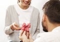 Man holding gift box and giving girlfriend