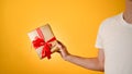 Man holding a gift close-up  on a yellow background Royalty Free Stock Photo