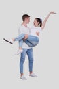 Man Holding Girl in his Arms. Couple Standing Isolated. Lovely Couple Looking at Each Other Girl is Happy and Holding Hand up. Royalty Free Stock Photo