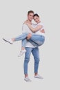 Man Holding Girl in his Arms. Couple Standing Isolated. Lovely Couple Looking to the Camera Royalty Free Stock Photo