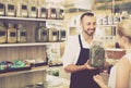 Man holding glass can with dried herbs