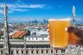 Man holding glass of light beer with view from Milan Cathedral Duomo di Milano roof in Italy. Milan skyline with modern Royalty Free Stock Photo
