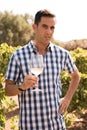 Man holding a glass of wine in a vineyard