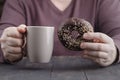 Man holding glazed donut and cup of coffee Royalty Free Stock Photo