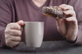 Man holding glazed donut and cup of coffee Royalty Free Stock Photo