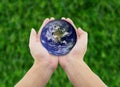 man holding globe with hands on grass background. Royalty Free Stock Photo