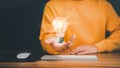 Man holding a glowing abstract light bulb with a computer keyboard on the table. Royalty Free Stock Photo