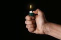 Man holding green lighter on black background, closeup Royalty Free Stock Photo