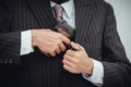 Man holding gun in his hand and trying to hide it in close-up view  on white background Royalty Free Stock Photo