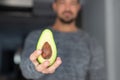 Man holding halved avocado selective focus