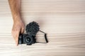 A man holding hand on little professional black camera with a microphone