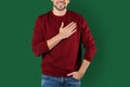 Man holding hand near his heart on color background