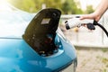 Man charging electric car. Man holding in hand power cable supply ready to plugged in into charging port Royalty Free Stock Photo