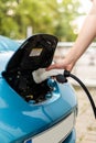 Man charging electric car. Man holding in hand power cable supply ready to plugged in into charging port Royalty Free Stock Photo