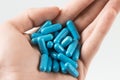 man holding handful of pills. suicide by blue capsule