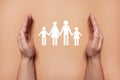 Man holding hands around paper silhouette of family on coral background, top view. Insurance concept Royalty Free Stock Photo