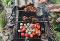 Man holding in hands grilled vegetables, chicken and pork meat on the open fire. Onions, mushrooms, tomatoes and red pepper on the Royalty Free Stock Photo