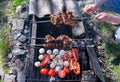 Man holding in hands grilled vegetables, chicken and pork meat on the open fire. Onions, mushrooms, tomatoes and red pepper on the Royalty Free Stock Photo