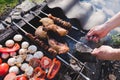 Man holding in hands grilled vegetables, chicken and pork meat on the open fire. Onions, mushrooms, tomatoes and red pepper on the Royalty Free Stock Photo