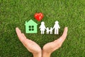 Man holding hands near of house, heart and family on green grass, top view