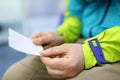 Man holding in hands sheet of paper with number in line