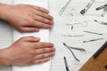 Man holding hands on towel near set of manicure tools at white wooden table, top view Royalty Free Stock Photo